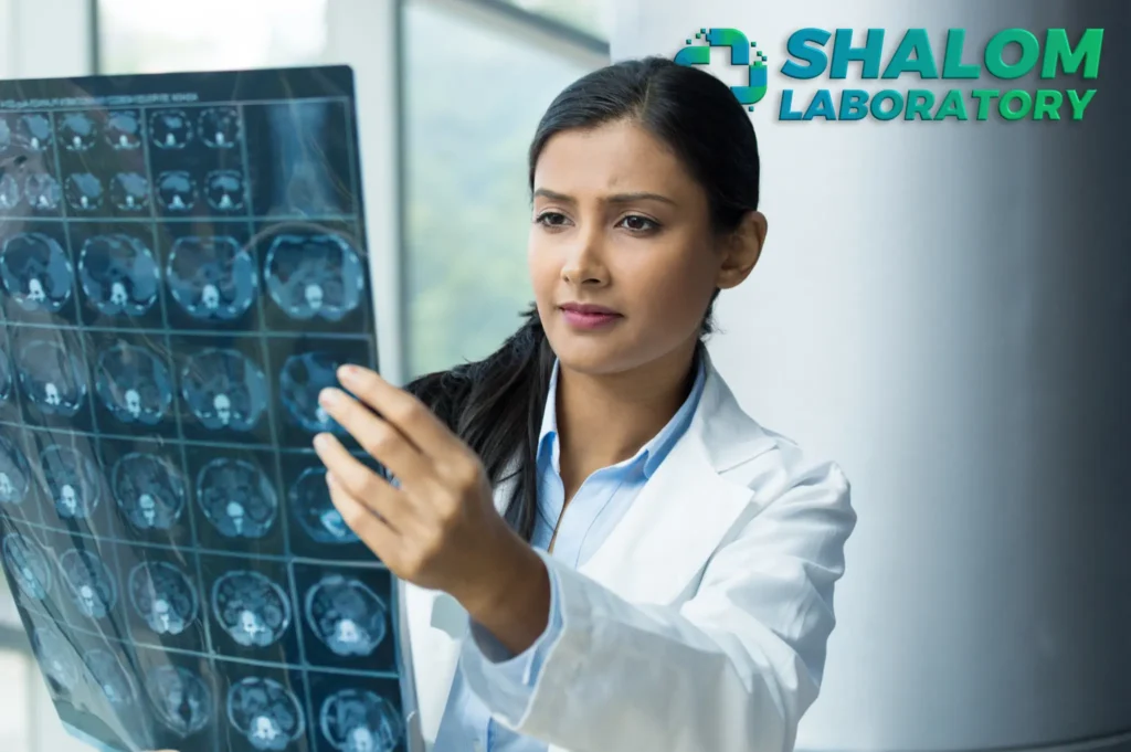 A radiologic technologist looking at an x-ray film